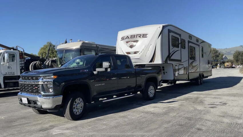 Chevy Silverado towing a fifth wheel trailer on the road