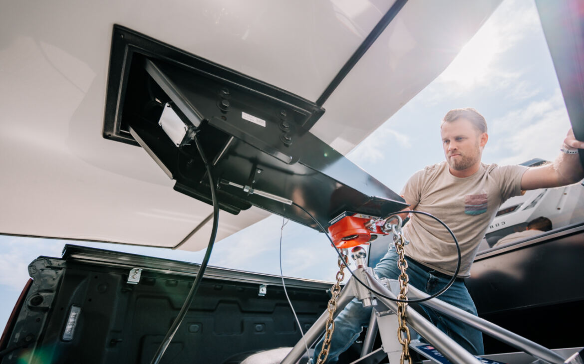 Man hooking up Fifth Wheel RV to hitch in Truck